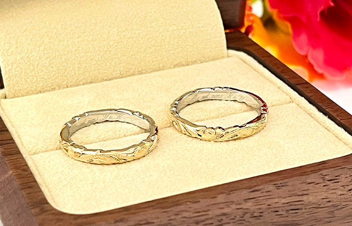 ハワイに思い入れをお持ちだったことから、ハワイアンジュエリーをご結婚指輪の候補として、指輪選びのご相談にマイレ大阪心斎橋店へお越し下さったY&K様。
 
おふたりがお選びいただいた指輪は、表面と内側の面それぞれに2層の異なる地金を組み合わせた「ダブルカラーリング」です。
急に金属アレルギーの反応が出るようになってしまい、以前ハワイでご購入されたゴールドの地金のリングの着用が叶わなくなってしまったK様も、表面にはお好みのゴールドを使用し、肌に直接触れる内側にプラチナを組み合わてダブルカラーにすることで、安心して着用いただけます。
