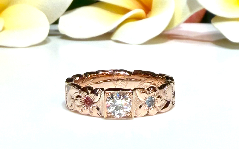 ⁡ お持ち込み頂いたリングからお取り外しさせて頂いた一粒ダイヤモンドをリングの中心にしっかりと埋め込み、両サイドには魅力を高める魔除けのお花「プルメリア」をポイント彫りに。
&nbsp;
また、その中心には淡く優しい色味の「アクアマリン」と「トルマリン」をセッティング。
&nbsp;
ダイヤモンド・アクアマリン・トルマリンの天然石と手彫りのコンビネーションによる相乗効果で、よりキラキラと輝きを放ちます。
