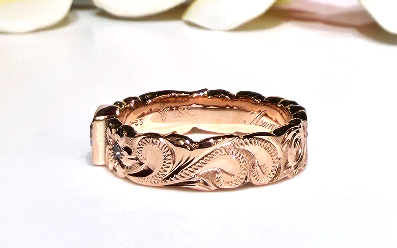 お選びいただいたハワイ伝統の手彫りのデザイン「プリンセス」は、〈愛と未来への希望〉という意味が込められ、寄せては返す波が、絶え間なく幸せを運んできてくれるとされています。
&nbsp;
波のアウトラインに沿ったジグザグの装飾彫り「リーグル」と砂模様を施す「サンドアウト」の加工によって、より一層存在感が際立ちます。
